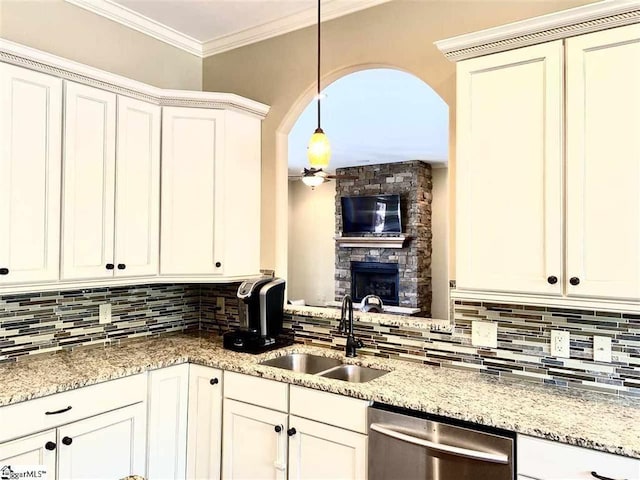 kitchen featuring decorative light fixtures, a fireplace, tasteful backsplash, dishwasher, and sink