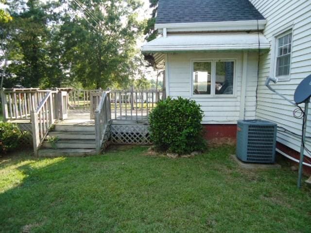 view of yard featuring a wooden deck and central AC unit