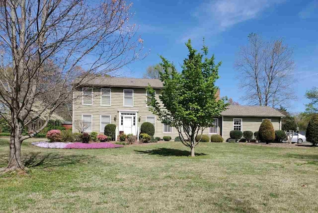 colonial-style house featuring a front yard