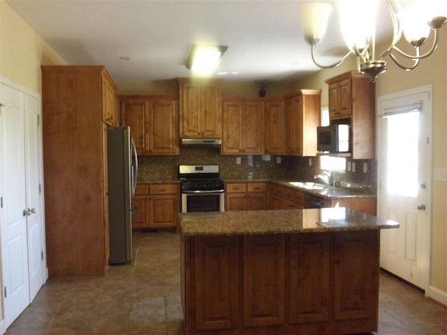 kitchen with tasteful backsplash, tile flooring, a chandelier, and stainless steel appliances