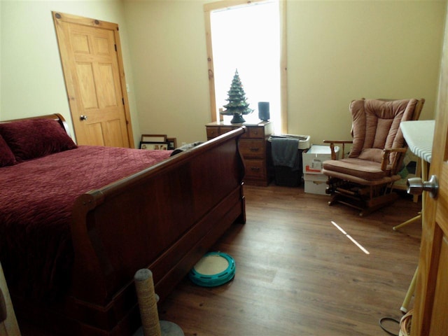 bedroom with dark hardwood / wood-style flooring