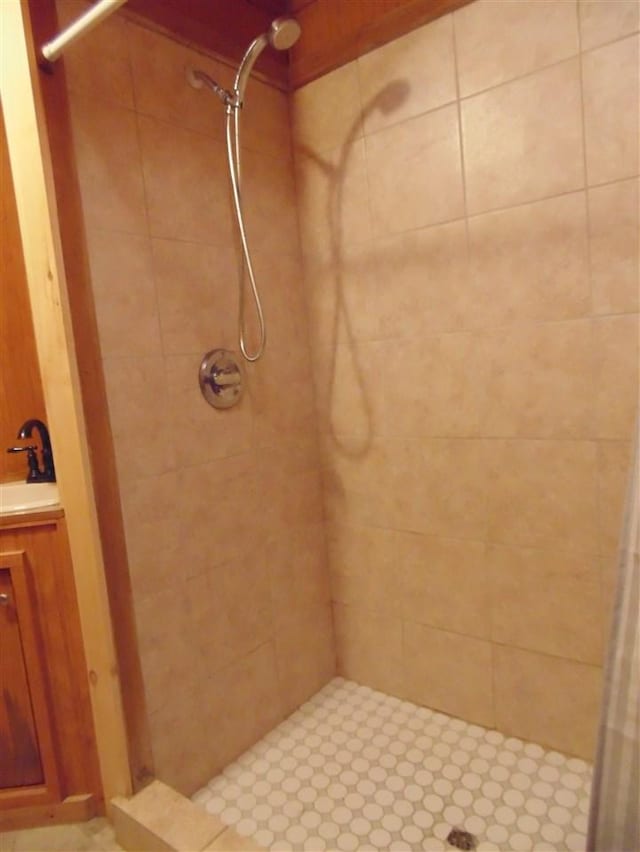 bathroom featuring tiled shower and vanity