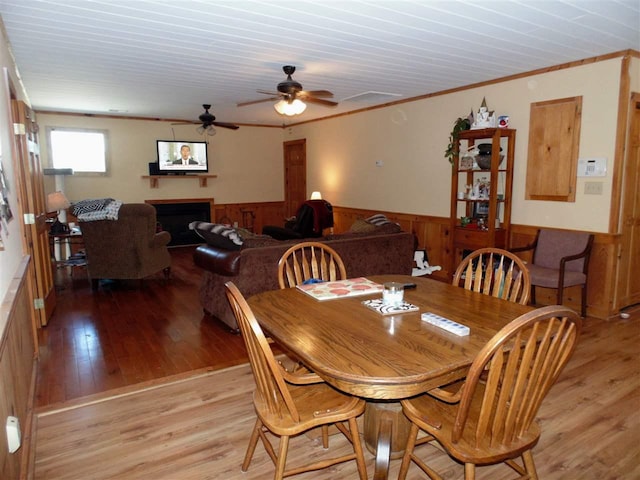 dining space with crown molding, ceiling fan, and light hardwood / wood-style flooring