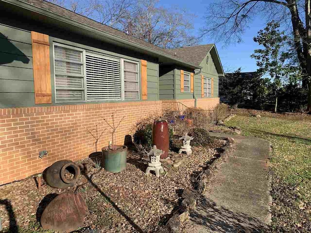 view of side of home with a yard