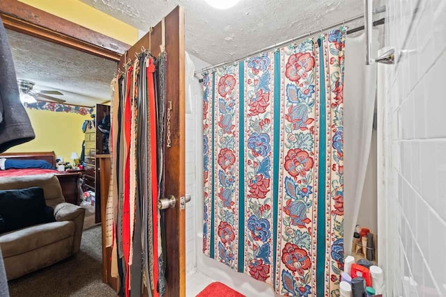 bathroom with ceiling fan and a textured ceiling