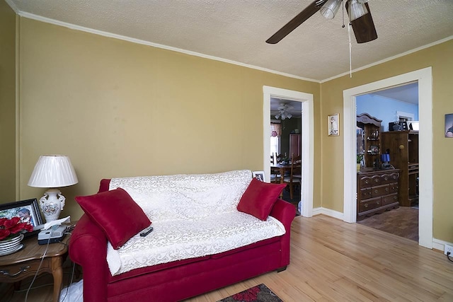 bedroom with light hardwood / wood-style floors, a textured ceiling, ceiling fan, and ornamental molding