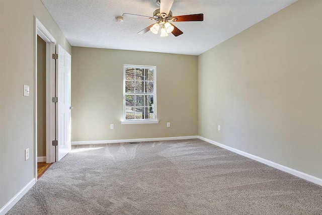 empty room featuring light carpet, a textured ceiling, and ceiling fan