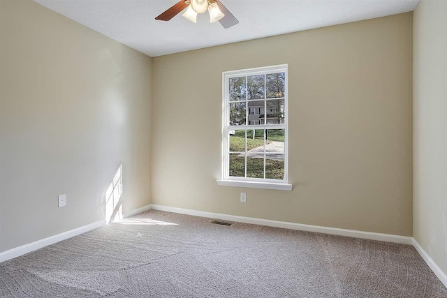 empty room with ceiling fan and light carpet