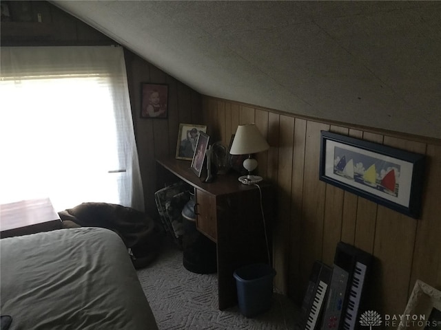 bedroom with multiple windows, lofted ceiling, and wooden walls