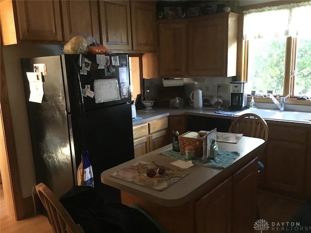 kitchen featuring black fridge and sink