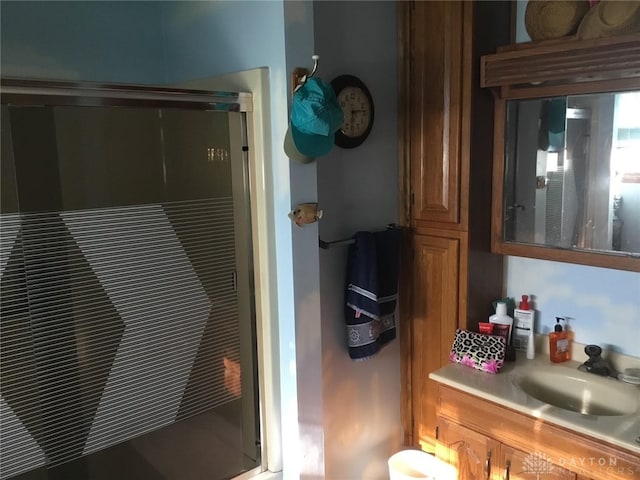 bathroom featuring walk in shower and vanity