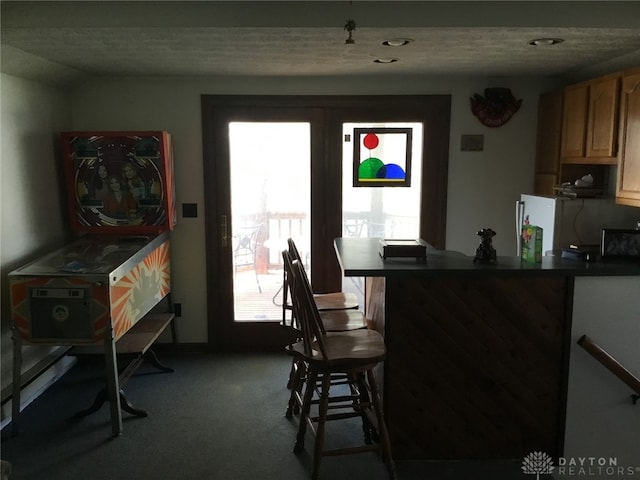 carpeted dining area with a wealth of natural light and a textured ceiling