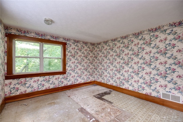 spare room with a textured ceiling