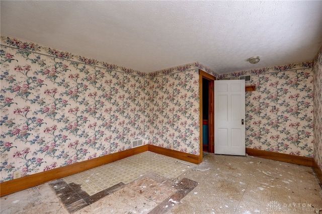 unfurnished room with a textured ceiling