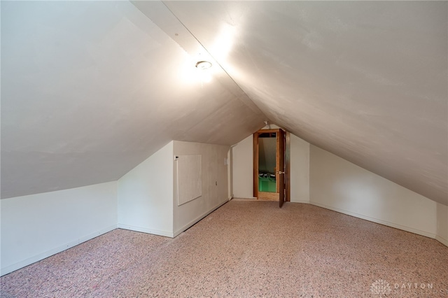 bonus room with light carpet and vaulted ceiling