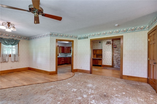 empty room featuring a textured ceiling, ceiling fan, and hardwood / wood-style floors