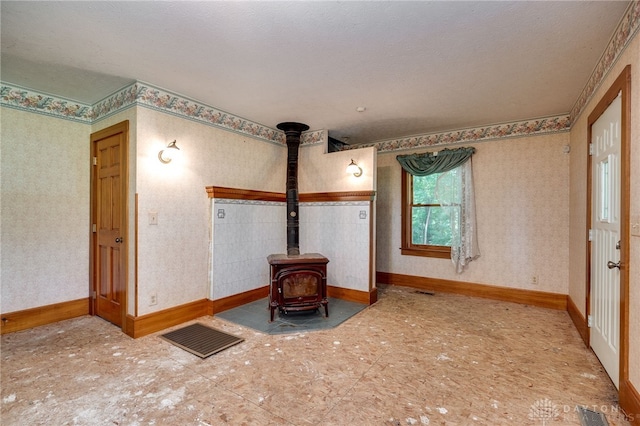 interior space with a textured ceiling and a wood stove