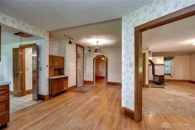 hall featuring a textured ceiling and light hardwood / wood-style flooring