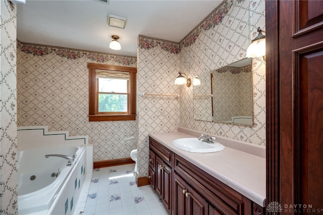 bathroom featuring tile patterned floors, vanity, toilet, and a tub