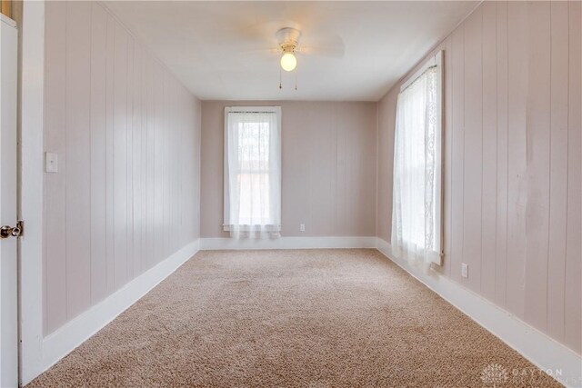 216 S Short St, Troy, OH 45373 - carpeted empty room featuring wood walls, ceiling fan, and baseboards