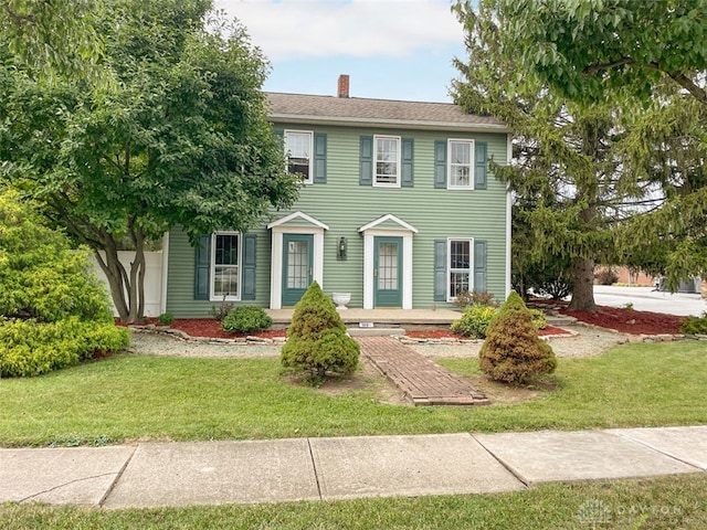 colonial-style house featuring a front lawn