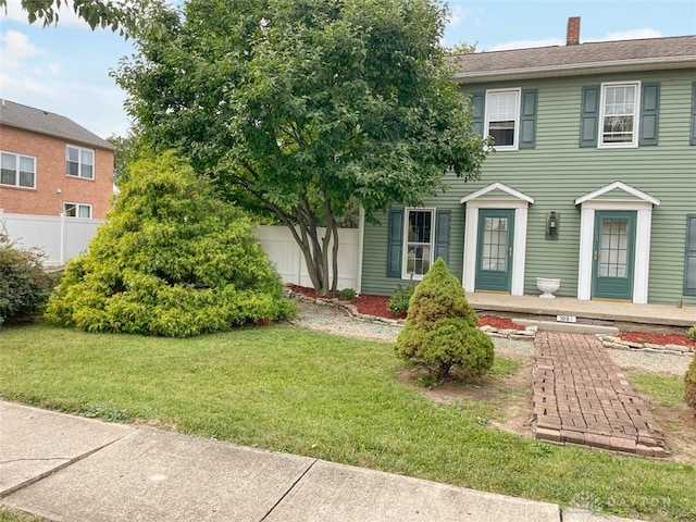 colonial-style house with a front lawn