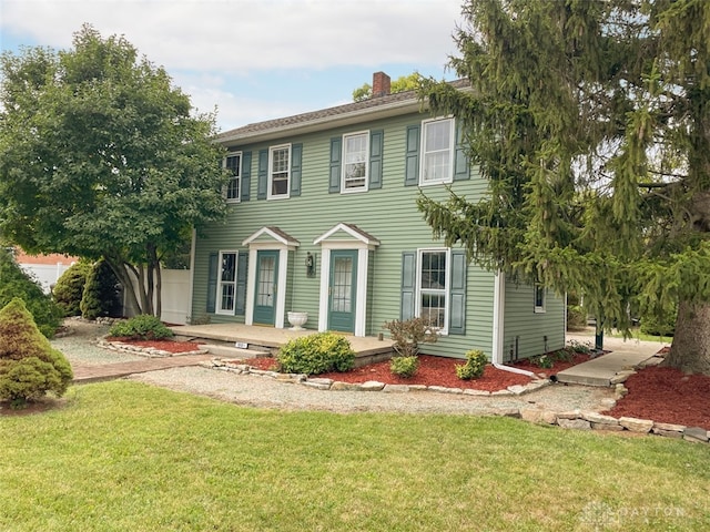 colonial-style house featuring a front lawn