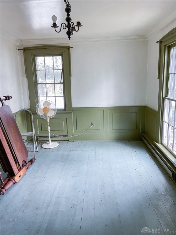 unfurnished room featuring an inviting chandelier, crown molding, and wood-type flooring