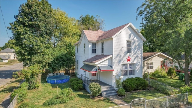 view of front facade with a swimming pool and a front lawn