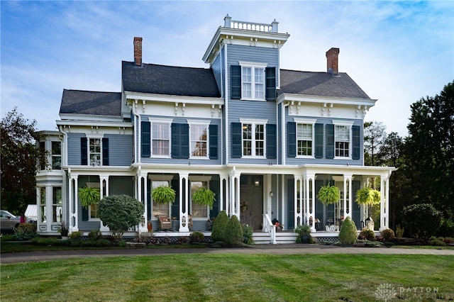 italianate-style house with a front yard and a porch