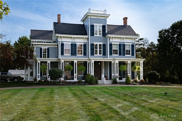 italianate-style house featuring covered porch and a front lawn