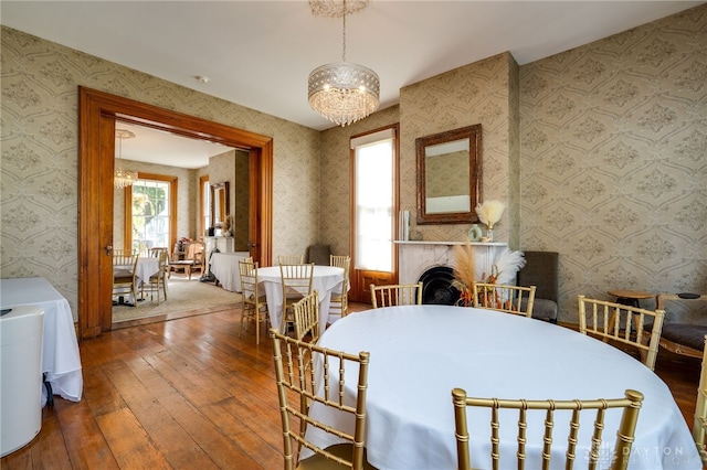 dining area with hardwood / wood-style flooring and an inviting chandelier