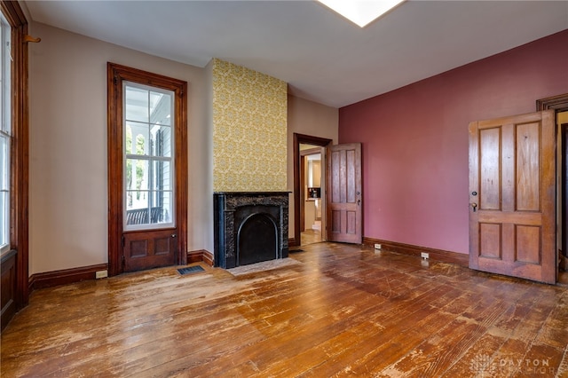 unfurnished living room featuring a high end fireplace and hardwood / wood-style floors