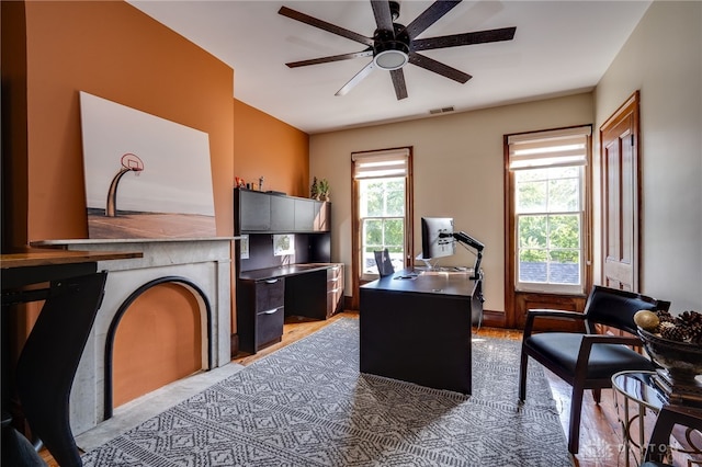 home office featuring ceiling fan, light wood-type flooring, and a wealth of natural light