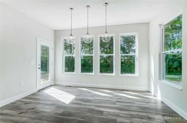 unfurnished dining area with a wealth of natural light and hardwood / wood-style flooring