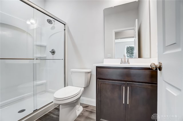 bathroom with an enclosed shower, vanity, hardwood / wood-style floors, and toilet