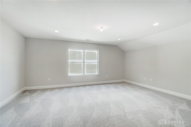 spare room with lofted ceiling and light carpet