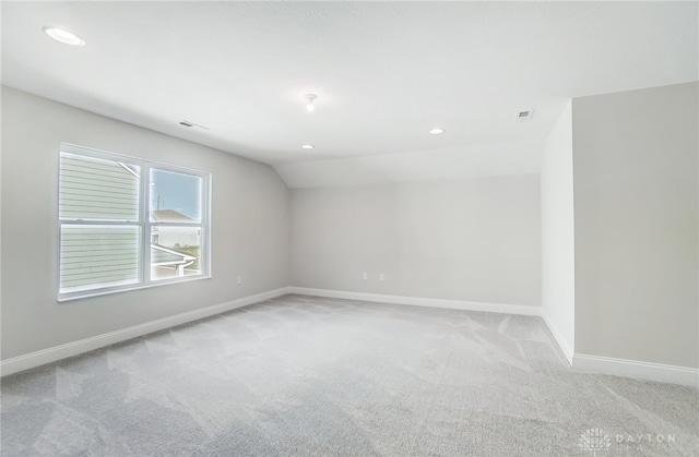 empty room with light carpet and lofted ceiling