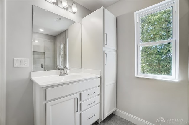 bathroom featuring tile patterned flooring, vanity, and a shower with shower door