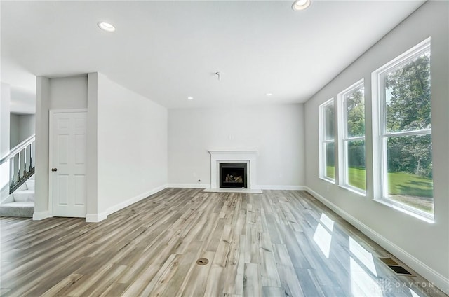 536 Hines Cir, Washington Twp, OH 45458 - unfurnished living room with light wood-type flooring, recessed lighting, stairway, baseboards, and a fireplace with flush hearth
