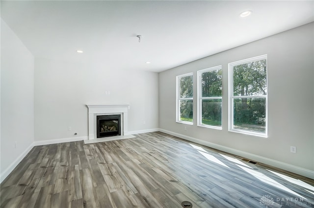 unfurnished living room with hardwood / wood-style flooring and a high end fireplace