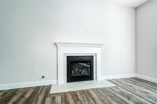 interior details featuring hardwood / wood-style flooring and a tiled fireplace