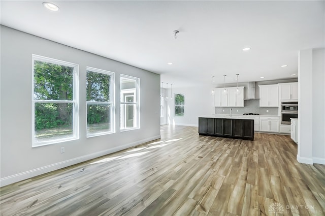 unfurnished living room with sink and light hardwood / wood-style flooring