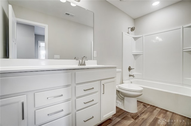 full bathroom featuring toilet, vanity, wood-type flooring, and shower / bath combination