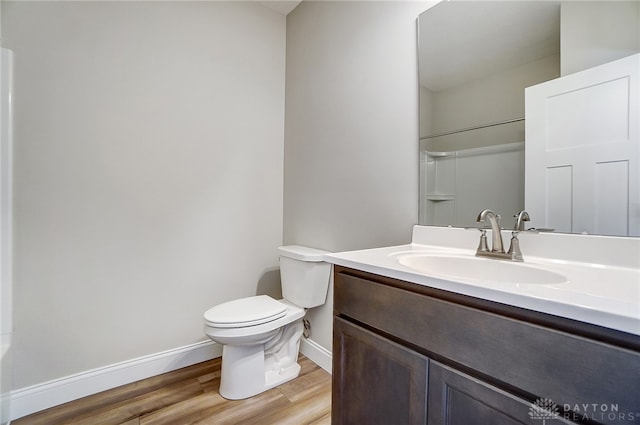 bathroom with a shower, wood-type flooring, toilet, and vanity