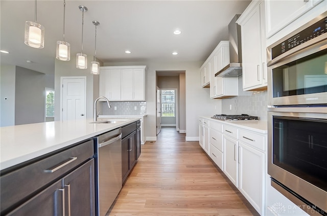 kitchen featuring backsplash, stainless steel appliances, light hardwood / wood-style floors, and sink