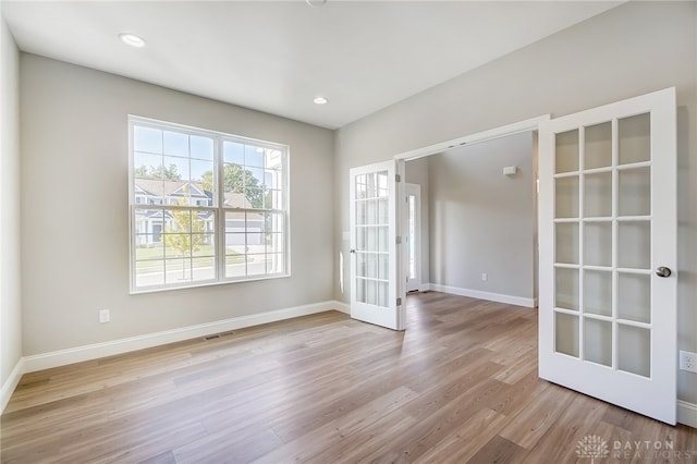 spare room with french doors and hardwood / wood-style floors