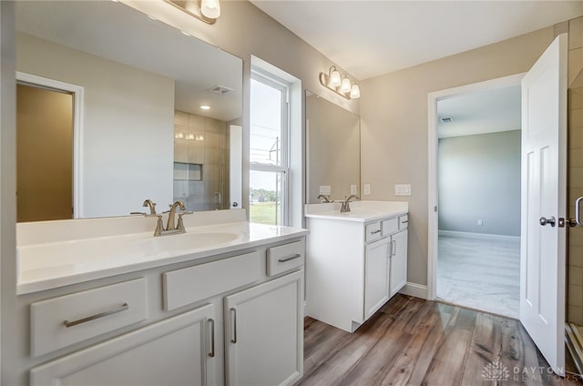 bathroom with vanity, hardwood / wood-style floors, and tiled shower