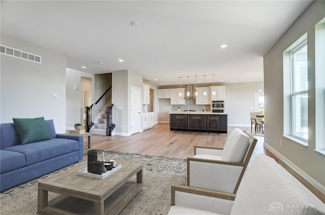 living room featuring sink and light hardwood / wood-style flooring