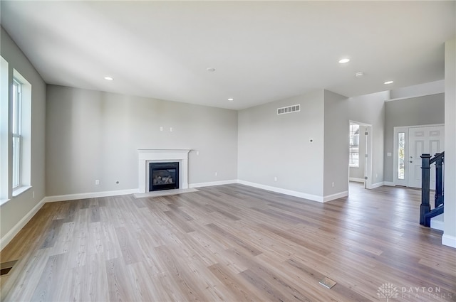 unfurnished living room featuring light hardwood / wood-style floors and a high end fireplace